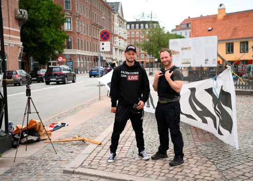 這裡有兩名示威者踐踏和焚燒 Al-Quran 週一（24 年 7 月 2023 日），伊拉克駐丹麥哥本哈根大使館前。 從半島電視台拍攝照片